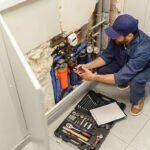 handyman-in-uniform-repairing-water-supply-system-9KGRWZ5.jpg